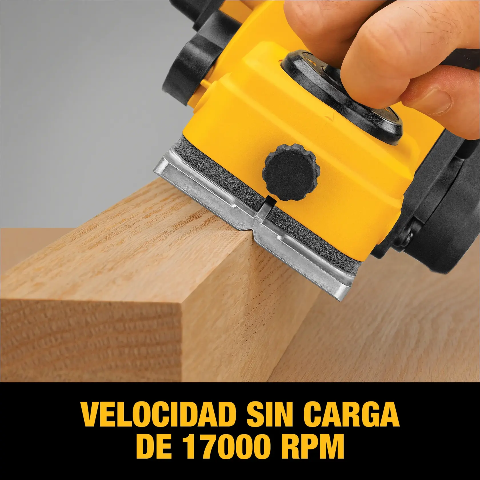 Primer plano de una cepilladora manual amarilla DEWALT utilizada para alisar una tabla de madera. La imagen resalta las especificaciones de la herramienta, indicando una velocidad sin carga de 17,000 RPM.