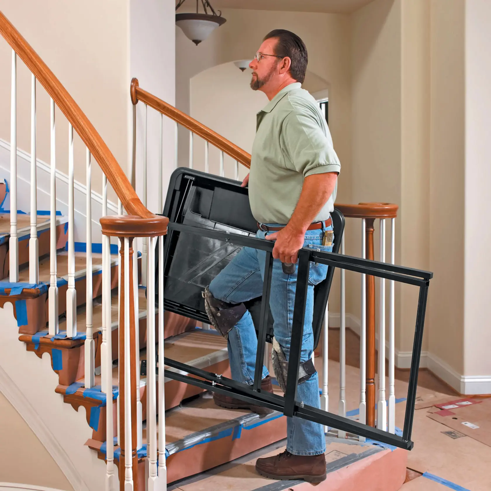 Persona llevando el marco del soporte para cortadora de baldosas DEWALT D24000 por unas escaleras cubiertas de protección.