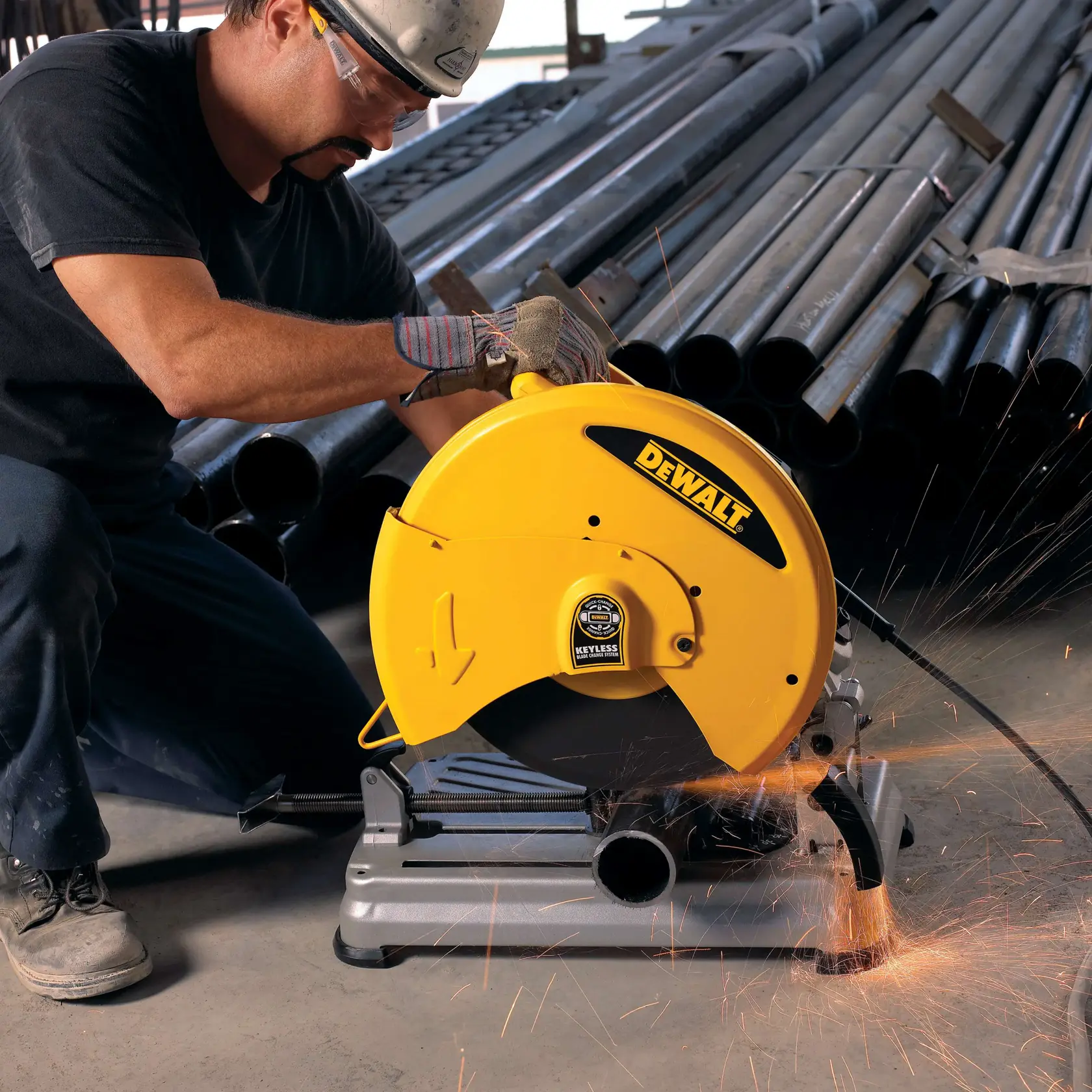 Una persona con guantes de trabajo y casco utiliza una sierra de corte DEWALT amarilla para cortar metal, mientras saltan chispas, dentro de un edificio con estructura de acero.