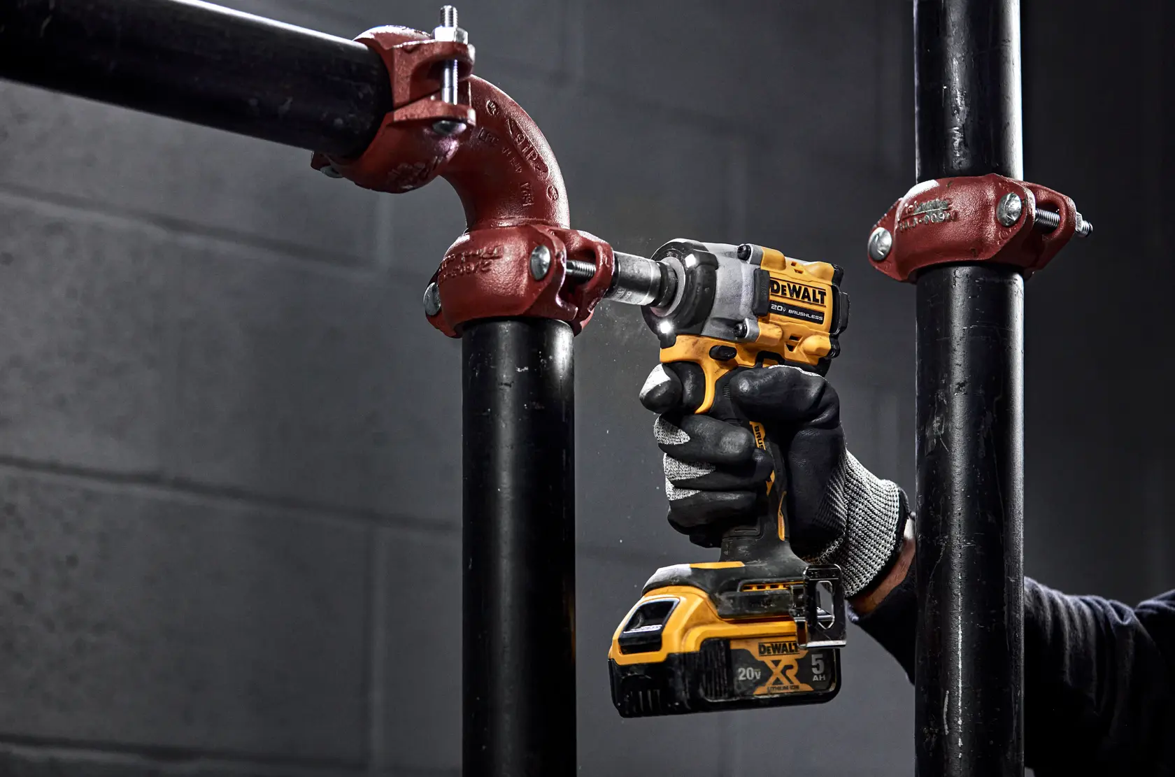 Una llave de impacto inalámbrica DEWALT 20V brushless, mostrada de pie sobre un fondo blanco. La herramienta es de color negro y amarillo con un clip de metal adjunto cerca de la base.