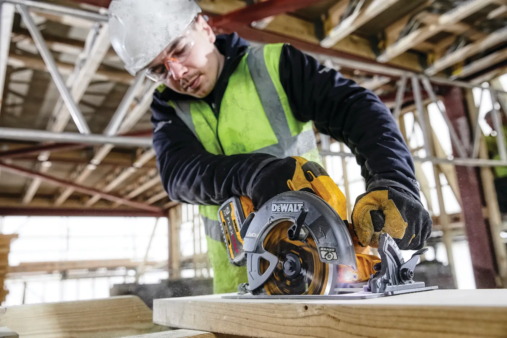 Persona con equipo usa una sierra circular DEWALT DCS578X2 para cortar madera en una obra.