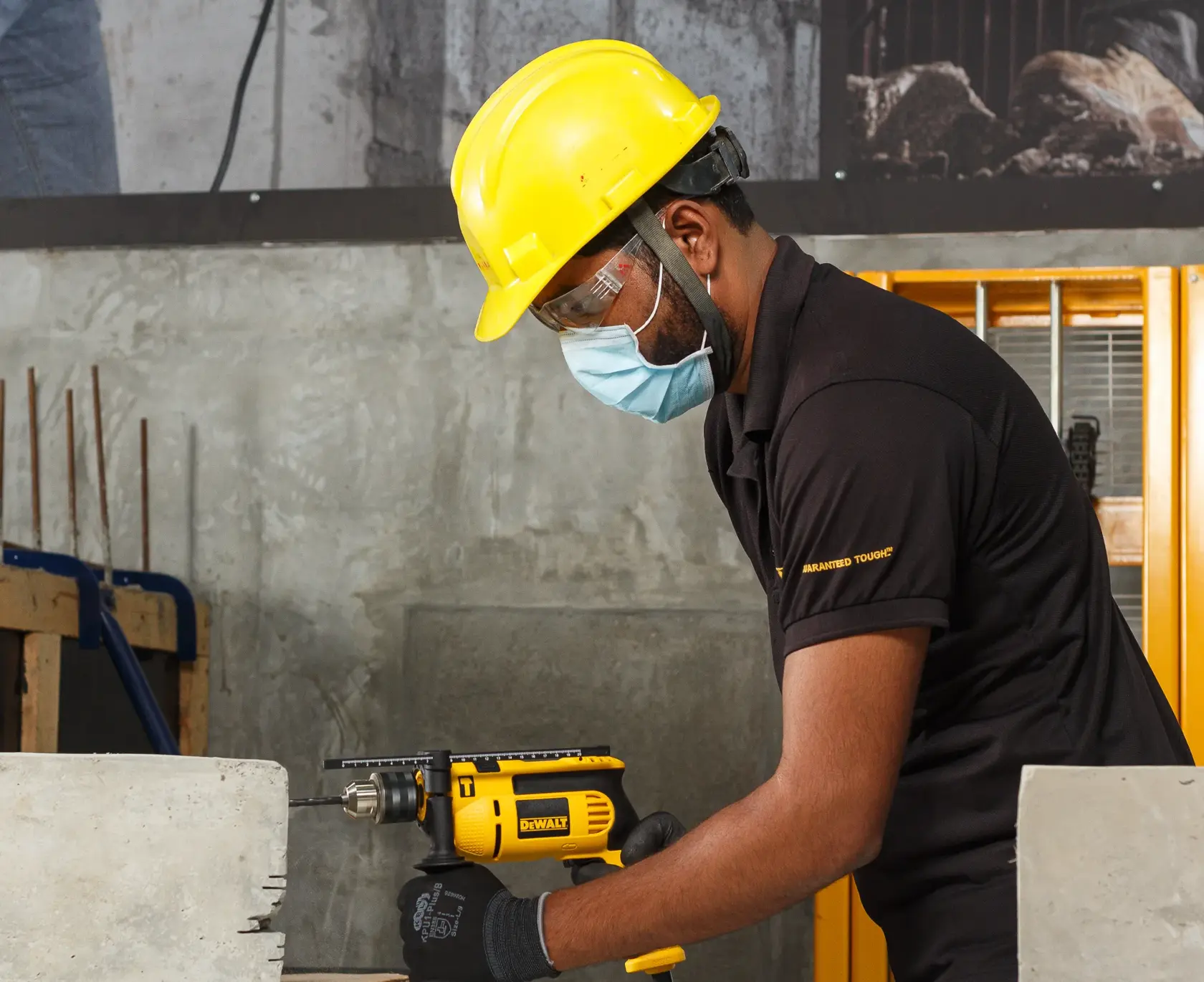 Trabajador usa taladro DEWALT DWD024-QS y DWD024 para perforar concreto en construcción.
