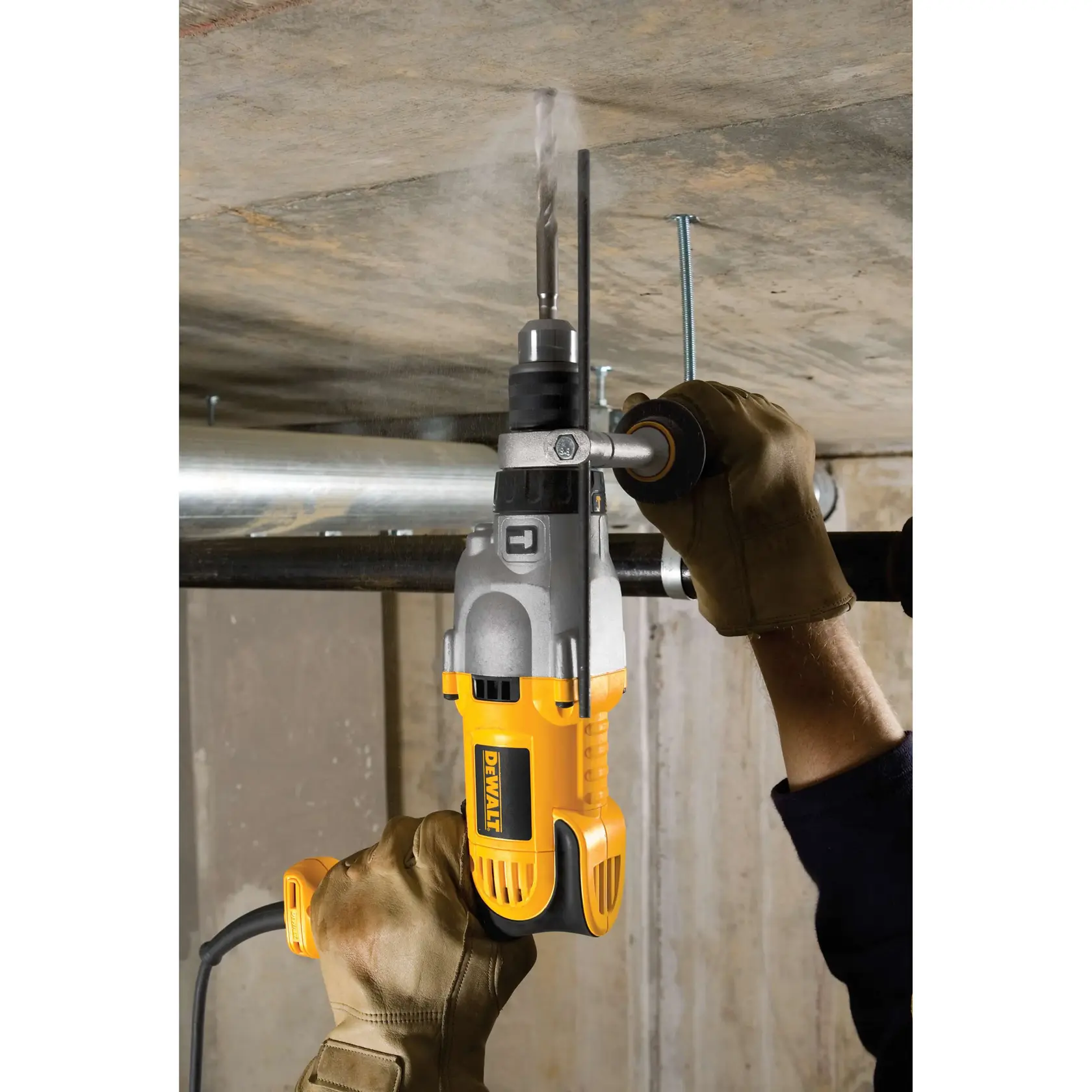 Una persona con guantes marrones está usando un taladro eléctrico amarillo y negro DEWALT para perforar un techo de hormigón.