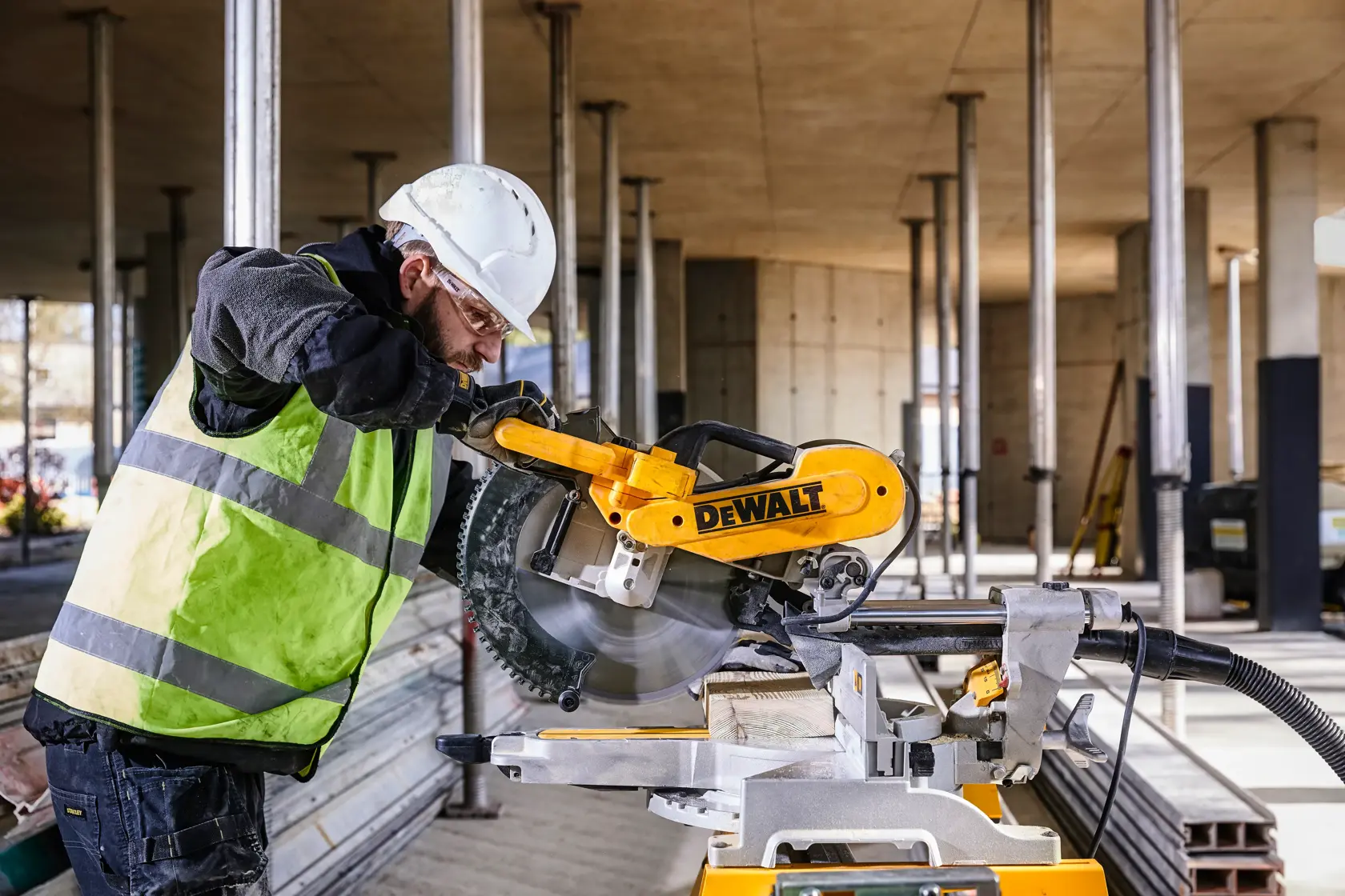 DEWALT DWS780, DWS780KIT sierra usada en obra. Trabajador con equipo de seguridad. Categoría fotografía.